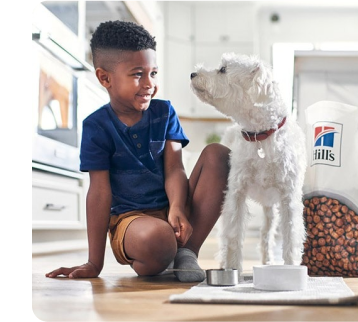 young boy and dog in kitchen